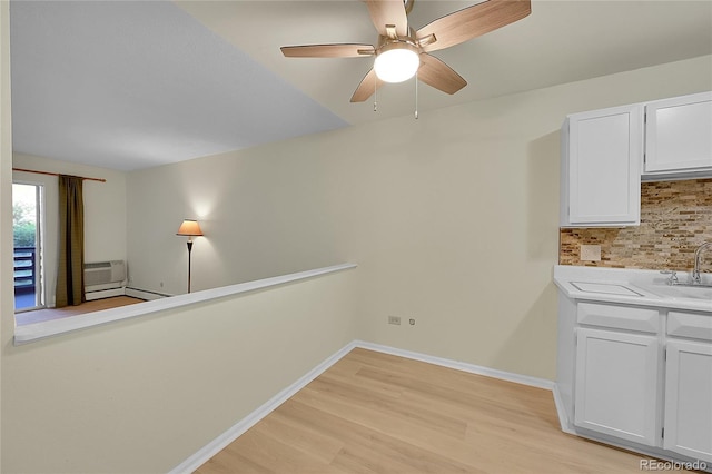635 S Alton Way Unit 6A, Denver, CO 80247 - kitchen featuring light wood-style flooring, tasteful backsplash, light countertops, ceiling fan, and white cabinets