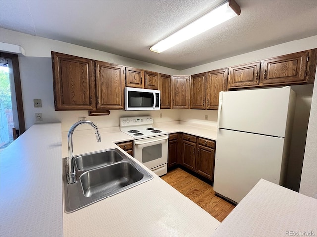 17969 E Brown Pl, Aurora, CO 80013 - kitchen featuring white appliances, a sink, light wood finished floors, and light countertops