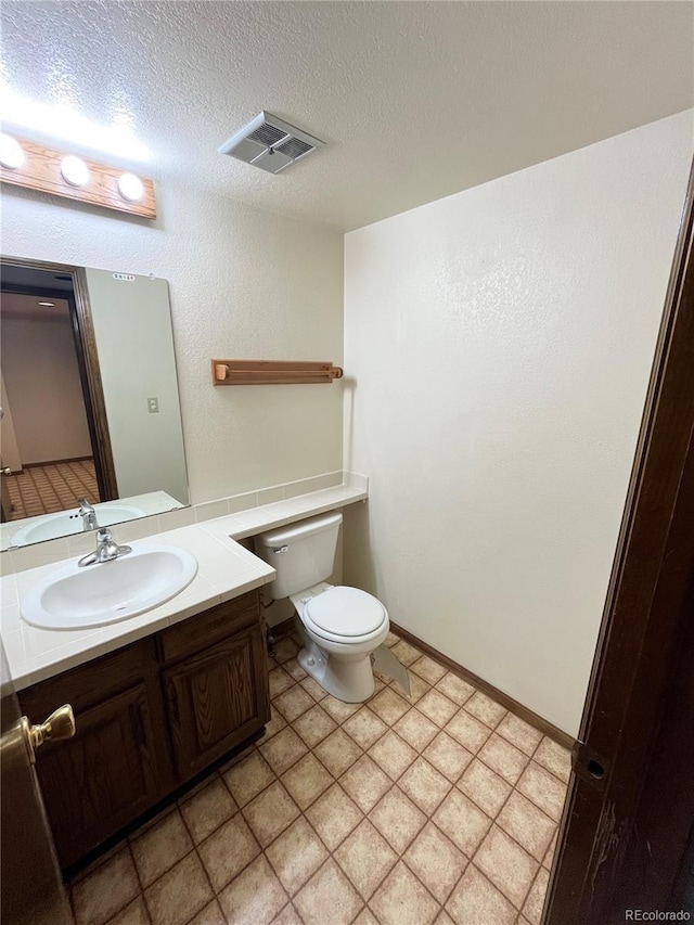 17969 E Brown Pl, Aurora, CO 80013 - half bath featuring toilet, vanity, and a textured ceiling