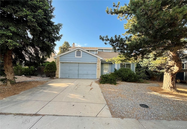 17969 E Brown Pl, Aurora, CO 80013 - view of front of home featuring concrete driveway, a garage, brick siding, and a chimney