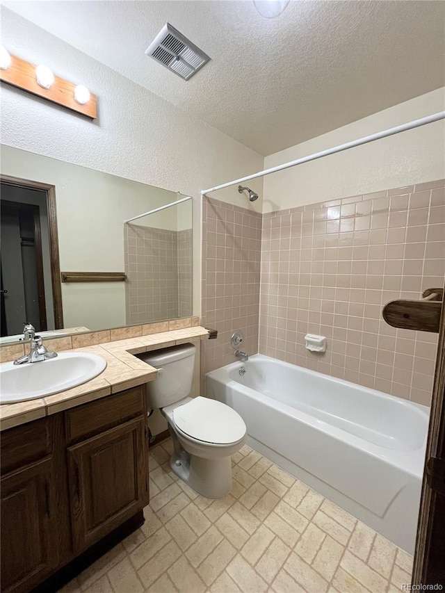 17969 E Brown Pl, Aurora, CO 80013 - full bath with tub / shower combination, toilet, vanity, brick patterned floors, and a textured ceiling