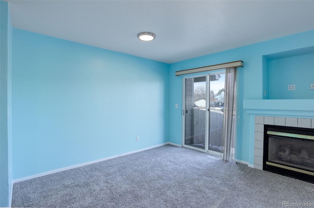 unfurnished living room with a tiled fireplace and carpet flooring