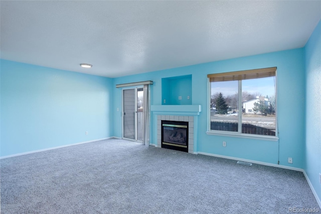 unfurnished living room featuring a fireplace, a textured ceiling, and carpet floors