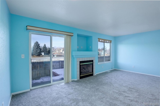 unfurnished living room with carpet and a fireplace