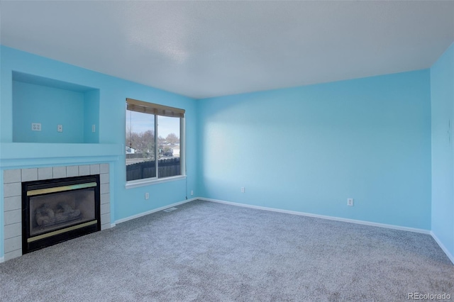 unfurnished living room with carpet and a fireplace