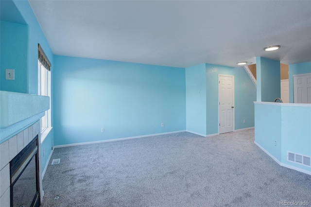 unfurnished living room with a fireplace and carpet