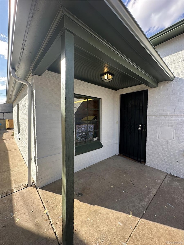 doorway to property with brick siding