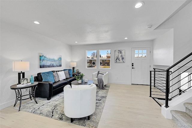 living room with light hardwood / wood-style floors and a textured ceiling