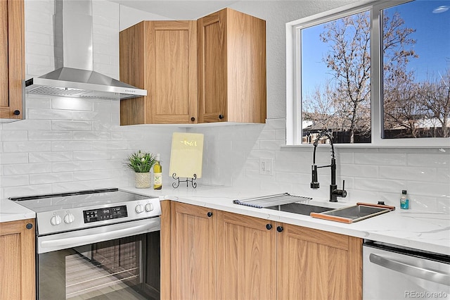 kitchen featuring stainless steel appliances, tasteful backsplash, sink, and wall chimney exhaust hood