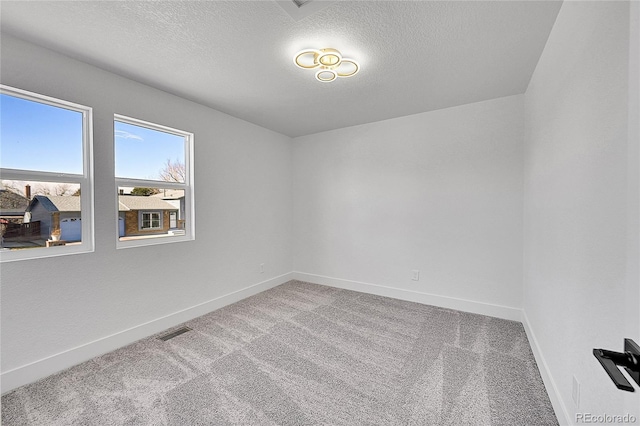 spare room with light carpet and a textured ceiling