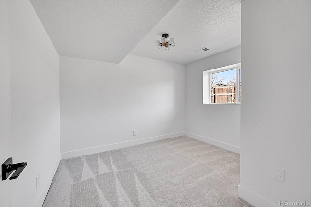 carpeted spare room with a textured ceiling