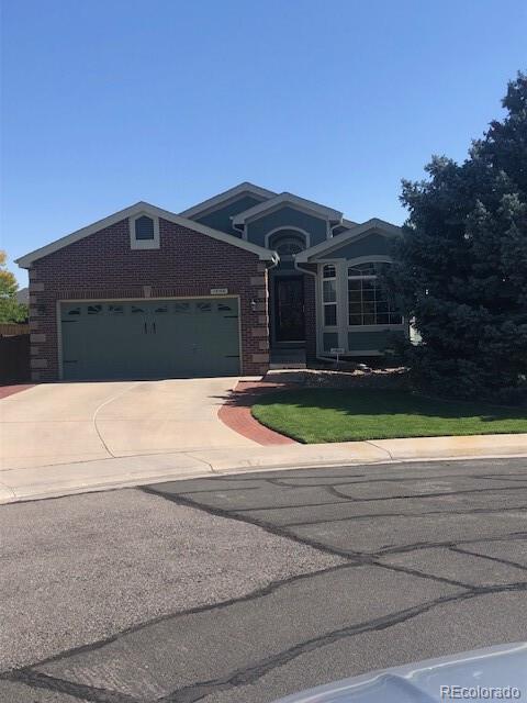 view of front of property featuring brick siding, driveway, and an attached garage