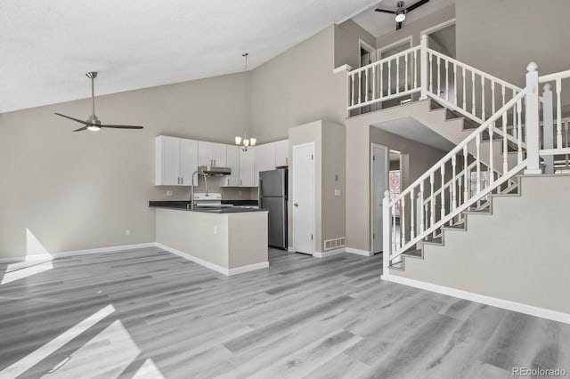 kitchen with freestanding refrigerator, ceiling fan, open floor plan, and high vaulted ceiling