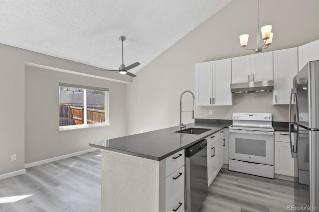 kitchen with stainless steel appliances, a sink, under cabinet range hood, dark countertops, and a textured ceiling