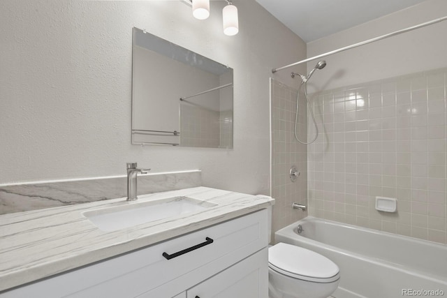 bathroom with shower / tub combination, toilet, vanity, and a textured wall