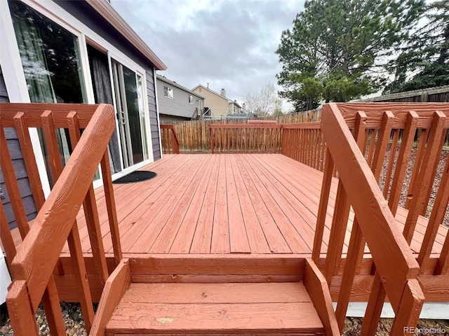 wooden deck with a fenced backyard