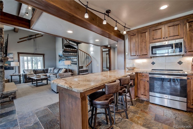 107 Ski Watch Rd Unit 32, Breckenridge, CO 80424 - kitchen with appliances with stainless steel finishes, stone tile flooring, light stone countertops, backsplash, and recessed lighting