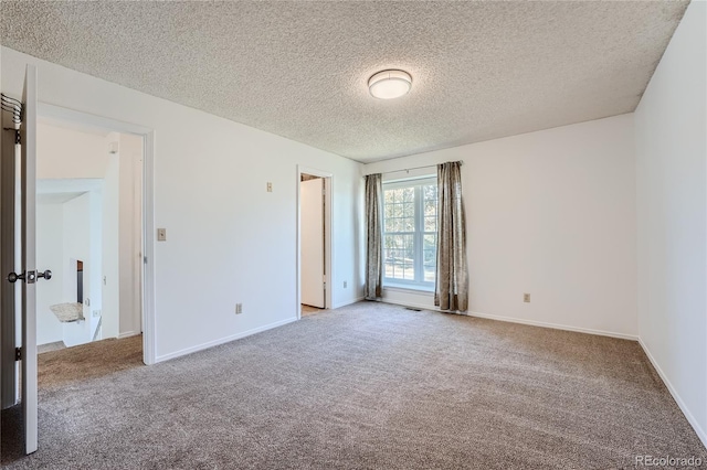 carpeted spare room with a textured ceiling