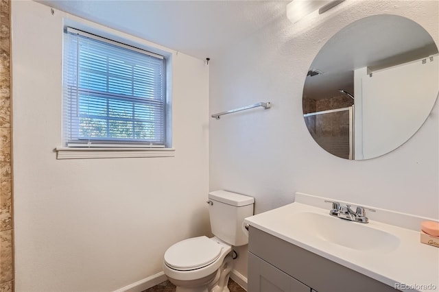 bathroom featuring vanity, toilet, and a shower with shower door