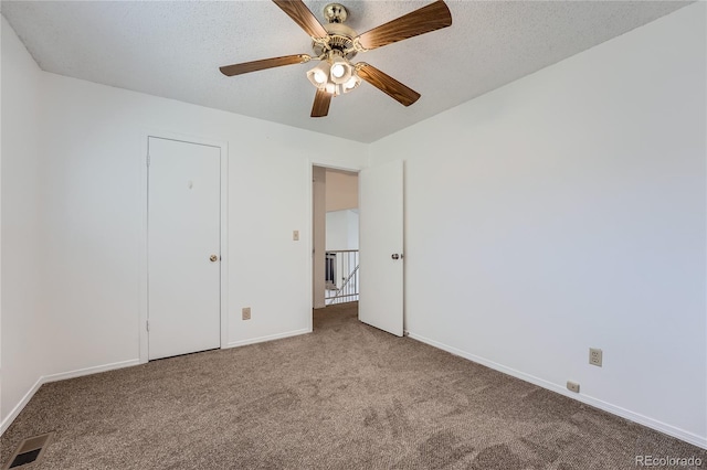 unfurnished bedroom featuring a textured ceiling, light colored carpet, and ceiling fan