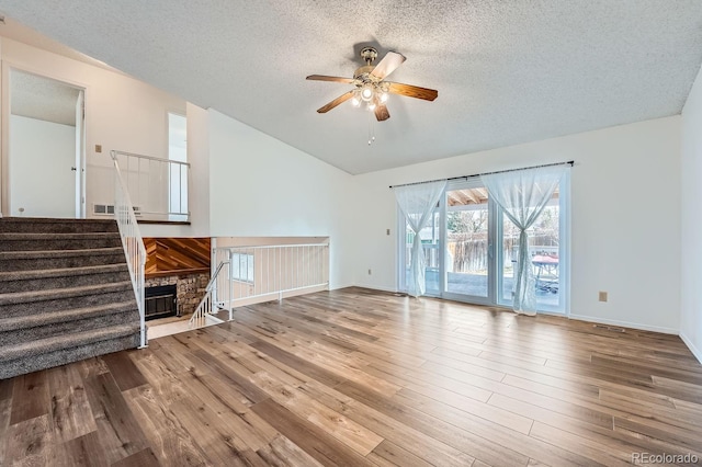 unfurnished living room featuring ceiling fan, wood-type flooring, and a textured ceiling