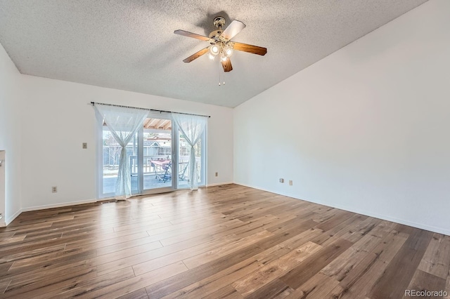 unfurnished room featuring lofted ceiling, ceiling fan, wood-type flooring, and a textured ceiling