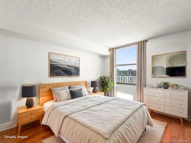 1301 Speer Blvd Unit 702, Denver, CO 80204 - bedroom featuring a textured ceiling and wood finished floors