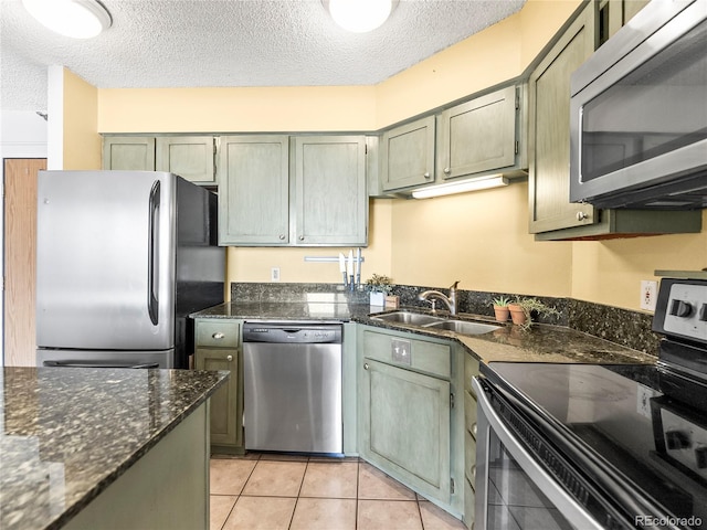 1301 Speer Blvd Unit 702, Denver, CO 80204 - kitchen featuring appliances with stainless steel finishes, a sink, a textured ceiling, light tile patterned floors, and dark stone counters