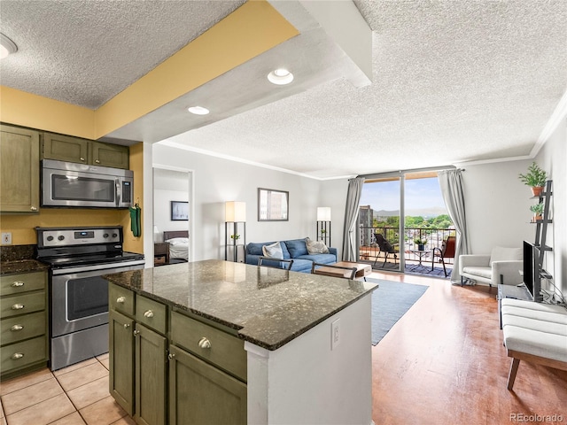 1301 Speer Blvd Unit 702, Denver, CO 80204 - kitchen with appliances with stainless steel finishes, open floor plan, a textured ceiling, ornamental molding, and a center island