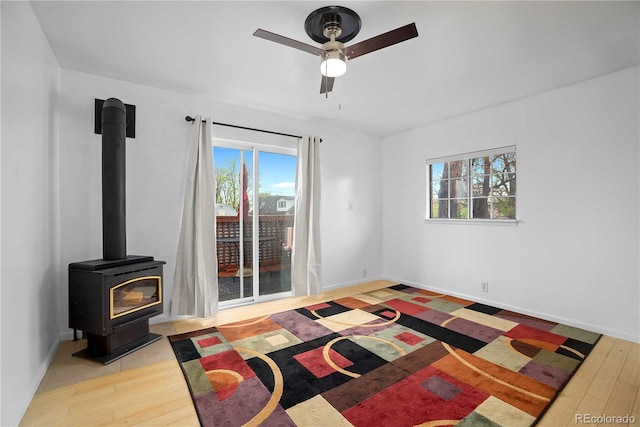 2627 Champa St, Denver, CO 80205 - bedroom featuring access to exterior, multiple windows, a wood stove, and wood finished floors