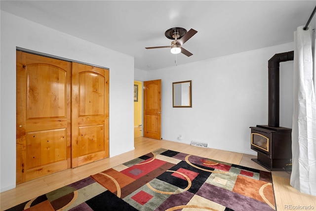 2627 Champa St, Denver, CO 80205 - bedroom with a wood stove, light wood finished floors, and ceiling fan