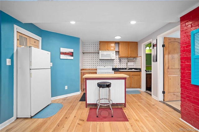 2627 Champa St, Denver, CO 80205 - kitchen featuring white appliances, light wood finished floors, brown cabinets, decorative backsplash, and recessed lighting