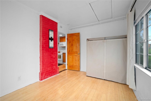 2627 Champa St, Denver, CO 80205 - unfurnished bedroom with attic access, light wood finished floors, ornamental molding, and a closet