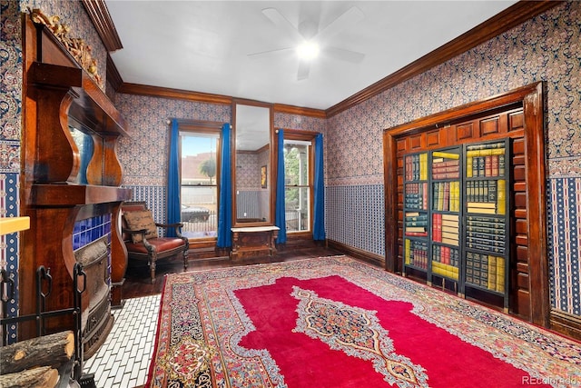 2627 Champa St, Denver, CO 80205 - sitting room with wallpapered walls, ornamental molding, a ceiling fan, wood finished floors, and a wainscoted wall