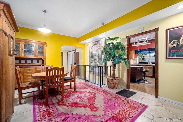 2627 Champa St, Denver, CO 80205 - dining area featuring ornamental molding, light tile patterned flooring, and arched walkways