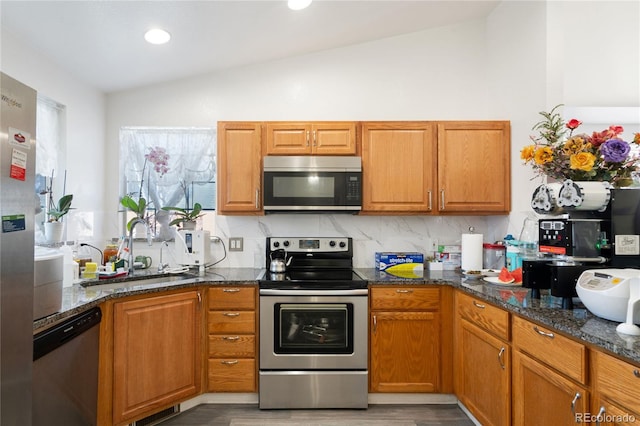 kitchen with backsplash, stainless steel appliances, sink, hardwood / wood-style flooring, and lofted ceiling