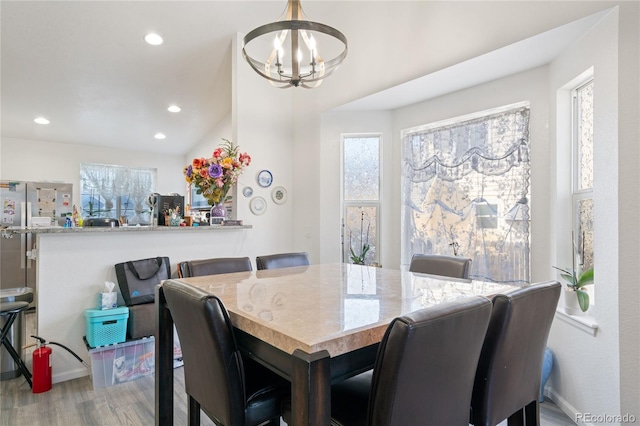 dining room featuring wood-type flooring, a wealth of natural light, and a notable chandelier