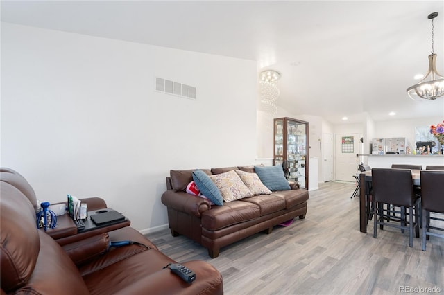 living room featuring a notable chandelier and light wood-type flooring