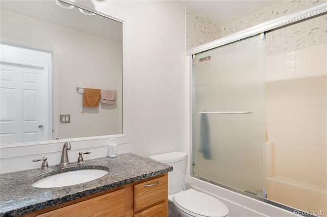 full bathroom featuring vanity, toilet, and combined bath / shower with glass door