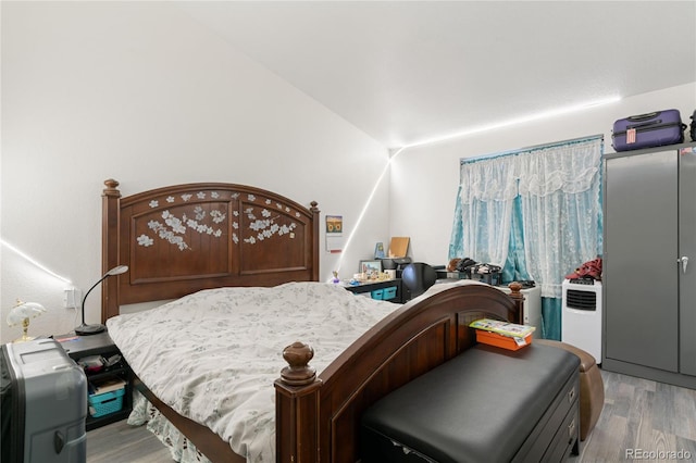 bedroom with hardwood / wood-style flooring and lofted ceiling