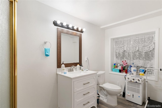 bathroom with hardwood / wood-style floors, oversized vanity, and toilet