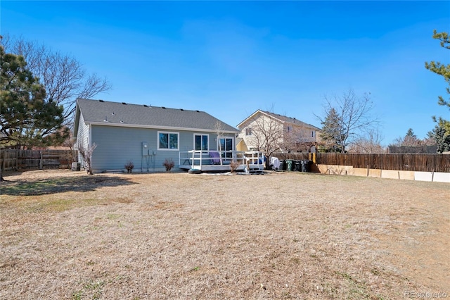 rear view of house featuring a yard and a deck