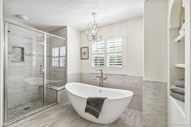 3411 Springbriar Dr, Castle Rock, CO 80109 - full bath with a freestanding bath, tile walls, a shower stall, a chandelier, and a wainscoted wall