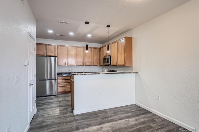 kitchen with dark hardwood / wood-style flooring, decorative light fixtures, stainless steel appliances, and kitchen peninsula