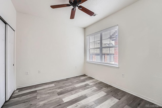 unfurnished bedroom with ceiling fan, light hardwood / wood-style floors, and a closet