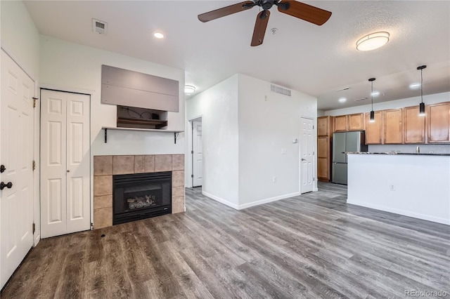 unfurnished living room with hardwood / wood-style floors, a fireplace, and ceiling fan