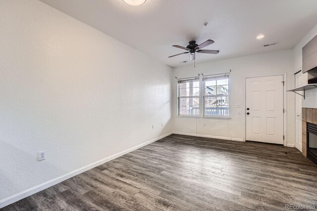 foyer with ceiling fan, dark hardwood / wood-style flooring, and a tile fireplace