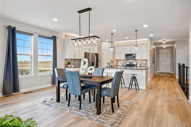 dining room with recessed lighting, baseboards, visible vents, and light wood-style floors