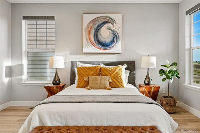 bedroom with baseboards and wood finished floors