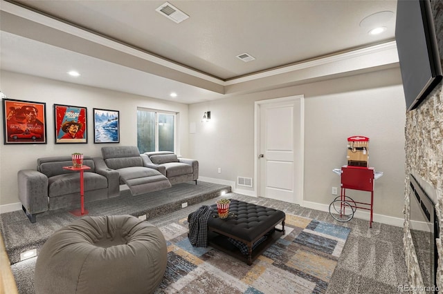 living area with recessed lighting, a stone fireplace, visible vents, and ornamental molding